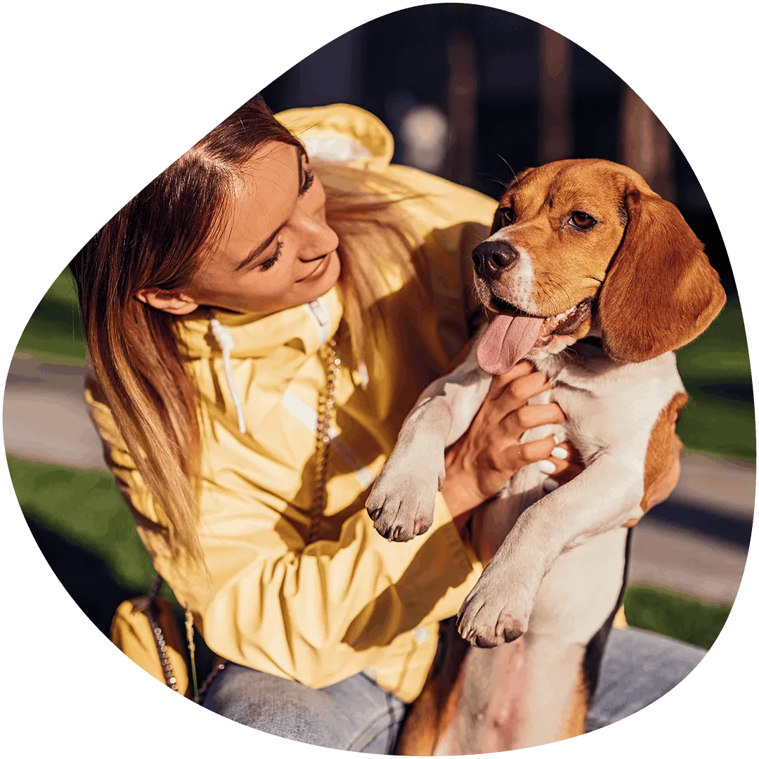 A woman holding a beagle